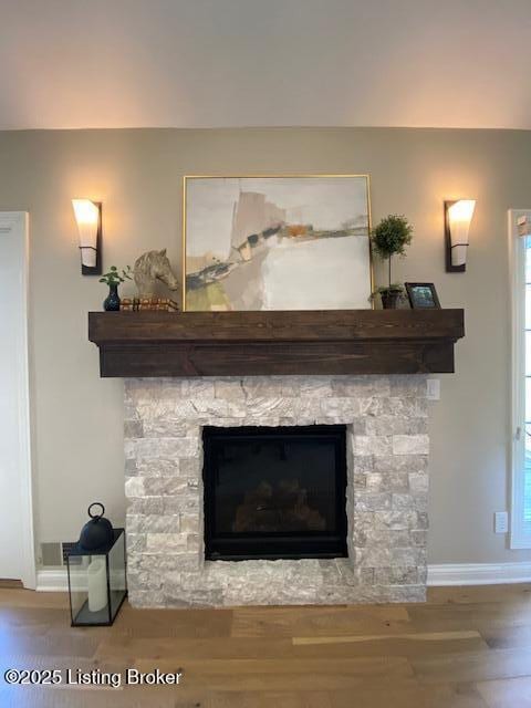 room details with hardwood / wood-style flooring and a stone fireplace