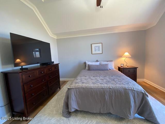 bedroom with crown molding, lofted ceiling, ceiling fan, and light hardwood / wood-style flooring