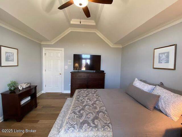 bedroom featuring vaulted ceiling, crown molding, ceiling fan, and dark hardwood / wood-style flooring