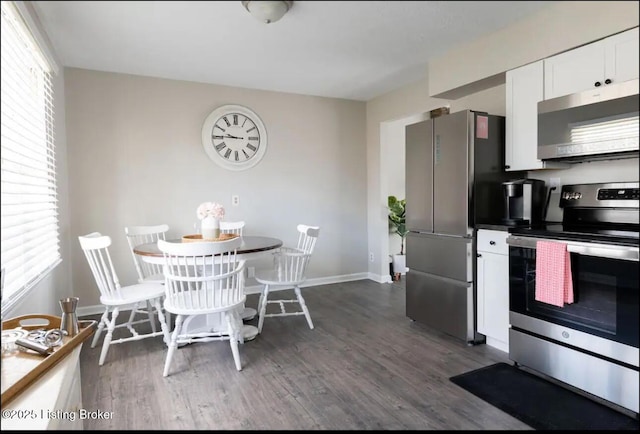 kitchen with white cabinetry, stainless steel appliances, and dark hardwood / wood-style flooring