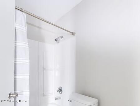 bathroom with shower / tub combo and toilet