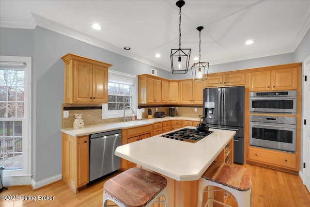 kitchen featuring a kitchen island, pendant lighting, sink, a kitchen breakfast bar, and stainless steel appliances