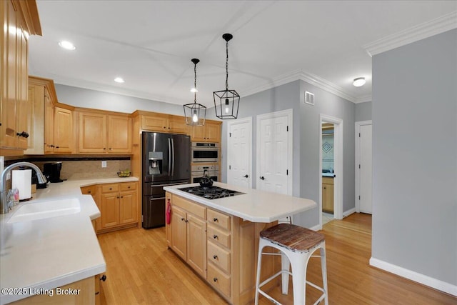 kitchen featuring black fridge with ice dispenser, sink, a kitchen breakfast bar, a kitchen island, and pendant lighting