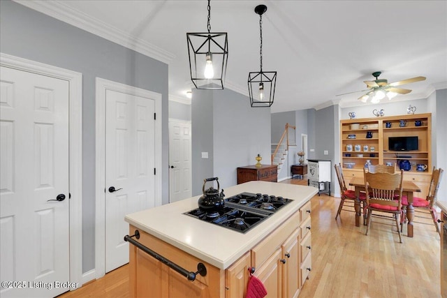 kitchen with a center island, ornamental molding, black gas stovetop, and light brown cabinets