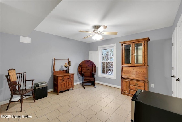 living area with ceiling fan and light tile patterned flooring