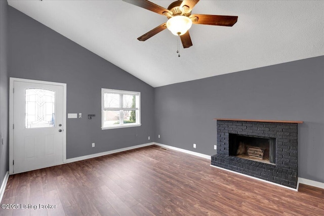 unfurnished living room featuring ceiling fan, lofted ceiling, dark hardwood / wood-style floors, and a brick fireplace