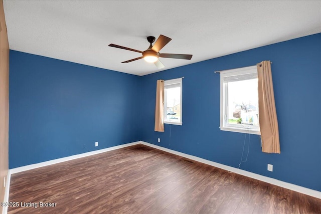 spare room with dark wood-type flooring and ceiling fan