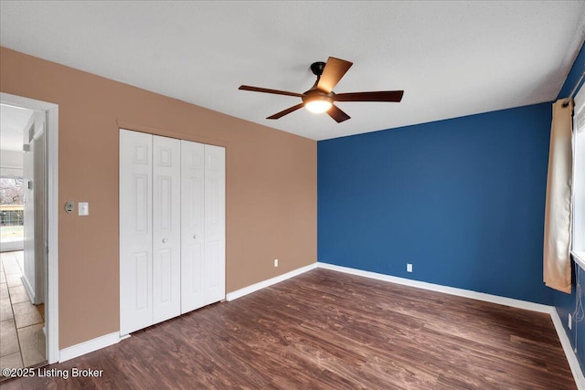 unfurnished bedroom featuring dark wood-type flooring, a closet, and ceiling fan