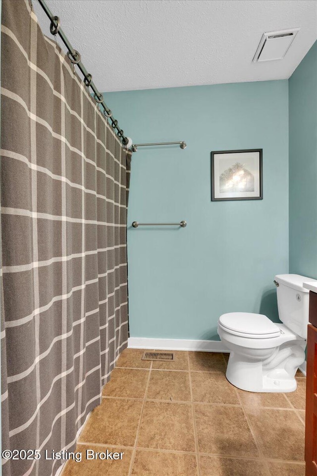 bathroom featuring tile patterned floors, a textured ceiling, and toilet