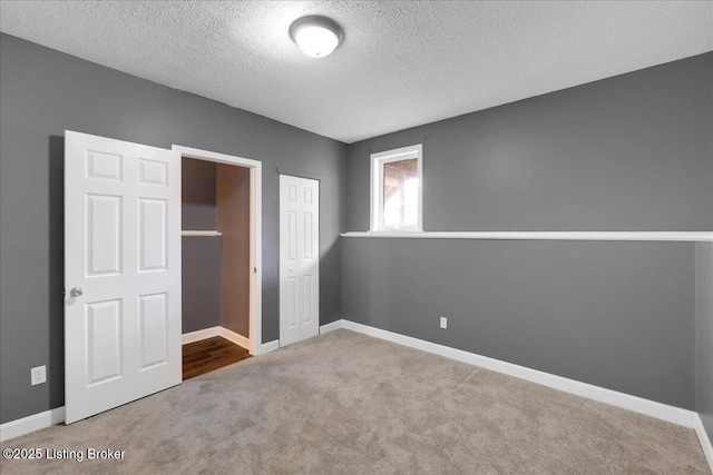 unfurnished bedroom featuring carpet floors, a closet, and a textured ceiling