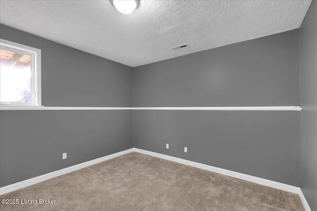 unfurnished room with a textured ceiling and carpet flooring