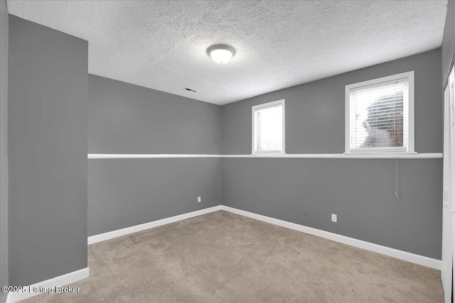 empty room featuring light carpet and a textured ceiling