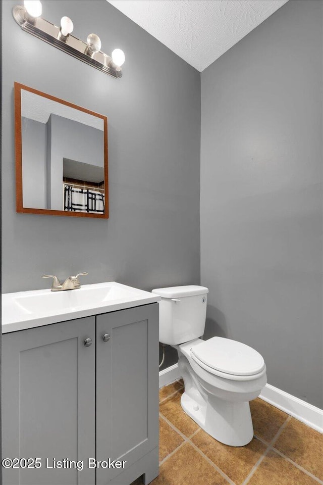 bathroom with vanity, tile patterned flooring, a textured ceiling, and toilet