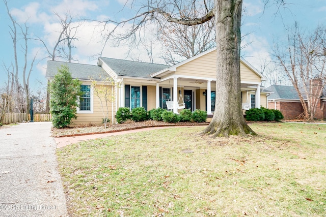 ranch-style home with a front yard and covered porch