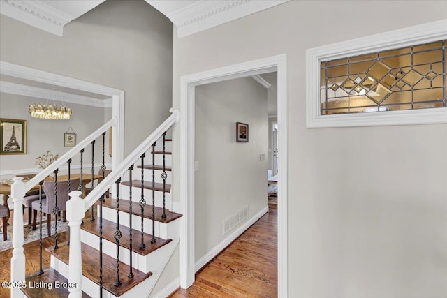 staircase featuring hardwood / wood-style flooring and crown molding