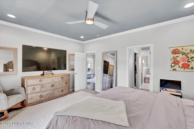 bedroom featuring light colored carpet, ornamental molding, ceiling fan, and ensuite bathroom