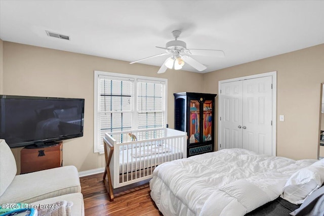 bedroom featuring a closet, dark hardwood / wood-style floors, and ceiling fan