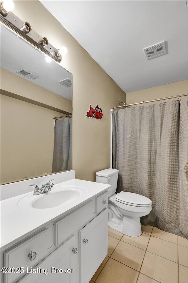 bathroom with tile patterned flooring, vanity, and toilet