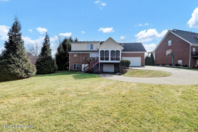 view of property with a sunroom, a front yard, and a garage