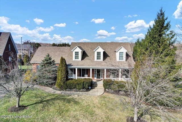 new england style home featuring a front yard and a porch