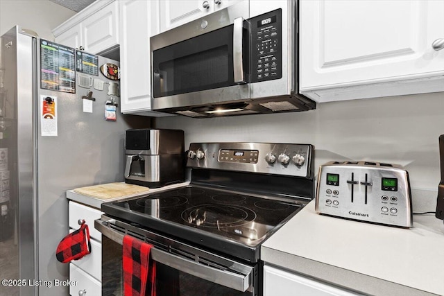 kitchen featuring stainless steel appliances and white cabinetry