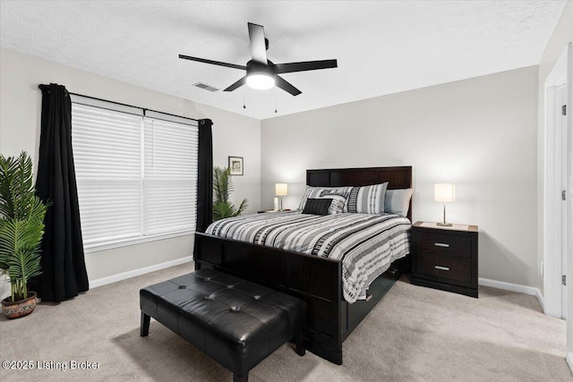 carpeted bedroom featuring ceiling fan and a textured ceiling