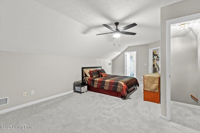 bedroom featuring vaulted ceiling, light carpet, ceiling fan, and a textured ceiling