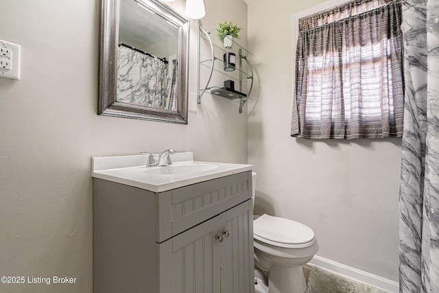 full bathroom with baseboards, vanity, and toilet