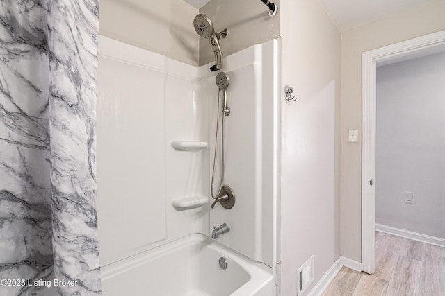 bathroom featuring shower / tub combo, visible vents, baseboards, and wood finished floors