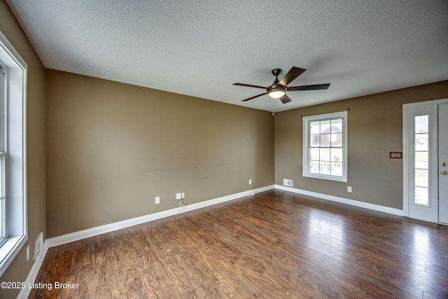 unfurnished room featuring dark wood-style floors, ceiling fan, a textured ceiling, and baseboards