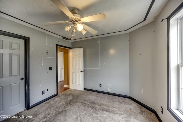 unfurnished bedroom with ceiling fan, carpet floors, and baseboards