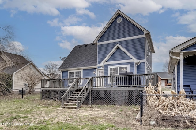 rear view of property with a shingled roof, fence, a deck, and stairs