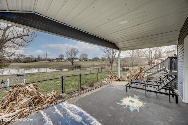 view of patio / terrace with a water view, a fenced backyard, and a gate