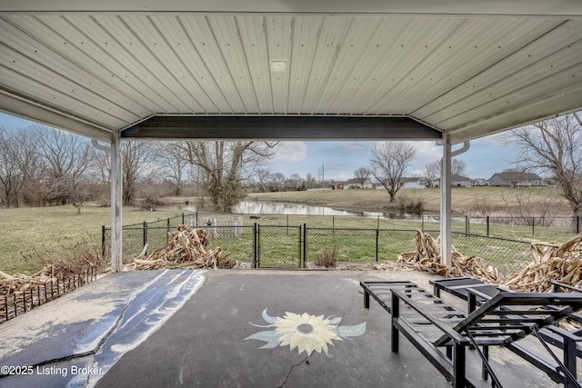 view of patio featuring a water view and fence