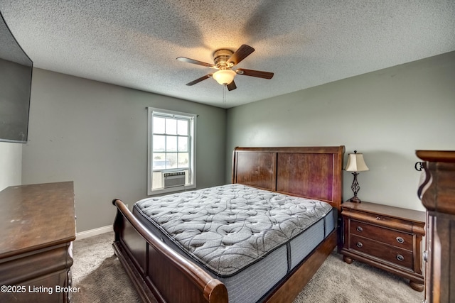 carpeted bedroom with ceiling fan, a textured ceiling, and baseboards