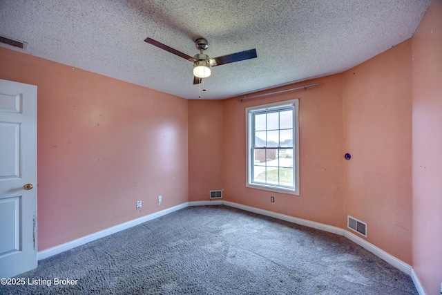 carpeted spare room featuring a textured ceiling, visible vents, and baseboards