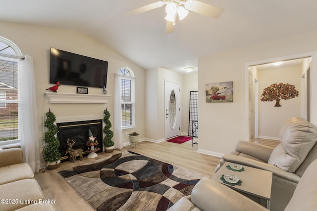 living room featuring ceiling fan, lofted ceiling, and light wood-type flooring