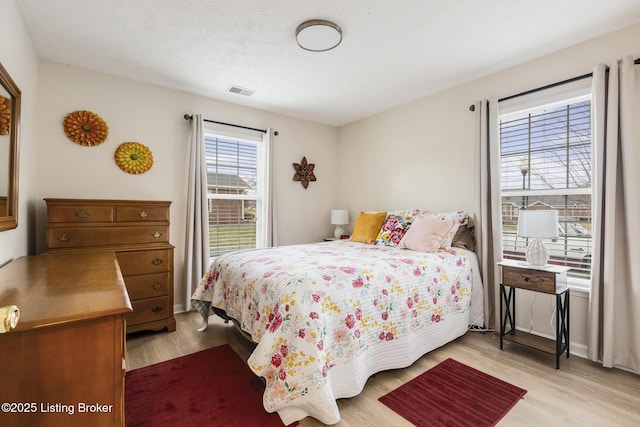 bedroom featuring light hardwood / wood-style floors and a textured ceiling