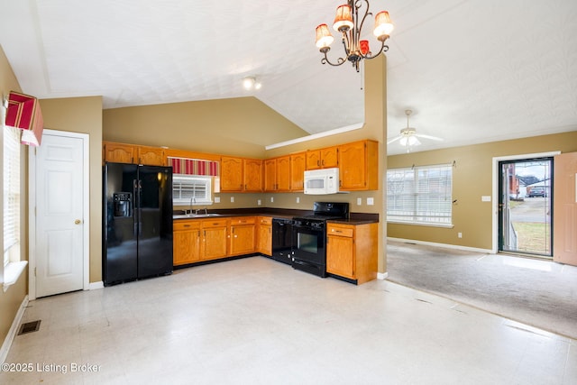 kitchen featuring lofted ceiling, sink, hanging light fixtures, ceiling fan with notable chandelier, and black appliances