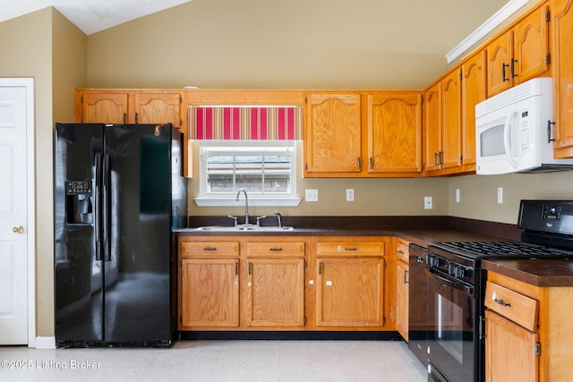 kitchen featuring lofted ceiling, sink, and black appliances