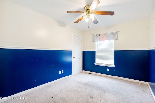 spare room featuring light colored carpet and ceiling fan