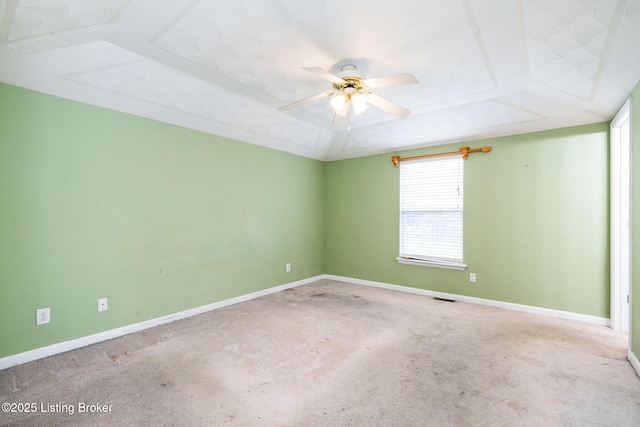 unfurnished room with ceiling fan, a raised ceiling, and light carpet