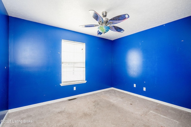 carpeted spare room with ceiling fan and a textured ceiling