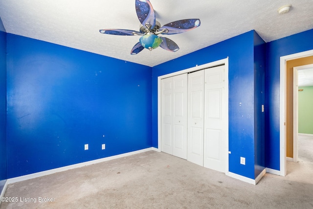 unfurnished bedroom featuring ceiling fan, a closet, carpet, and a textured ceiling