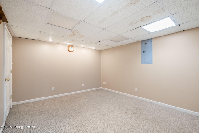 basement with carpet floors, electric panel, and a paneled ceiling