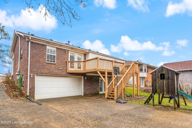 rear view of house with a garage and a deck