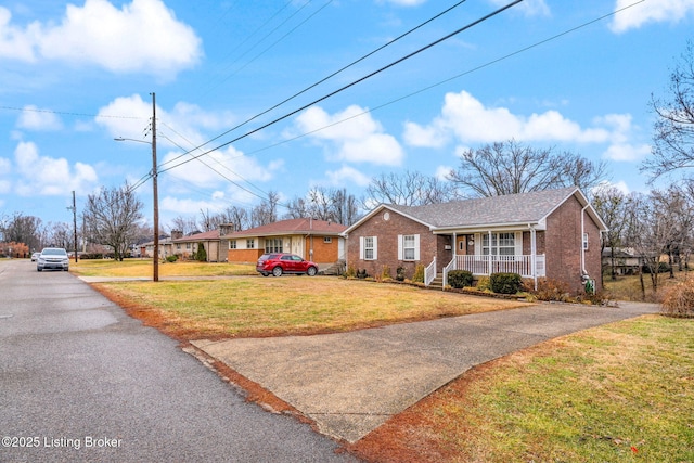 single story home with a porch and a front lawn