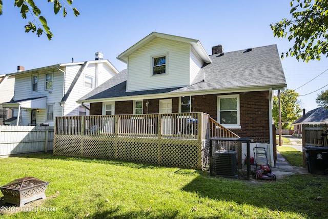 back of house with a wooden deck, a yard, central air condition unit, and a fire pit