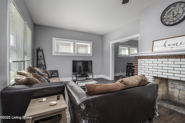 living room featuring a brick fireplace and dark hardwood / wood-style flooring