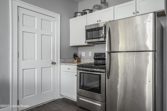 kitchen with dark hardwood / wood-style flooring, stainless steel appliances, and white cabinets